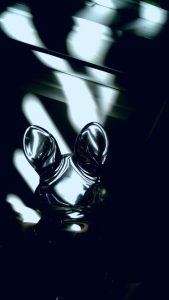 A photograph of a glass bunny figurine casting strange light on a wall.