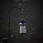 A photograph of a quaint birdhouse surrounded by snowflakes.