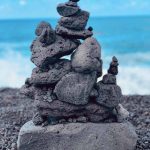 A photograph of an inuksuk at a beach.
