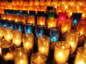 A photograph of dozens of lit candles.